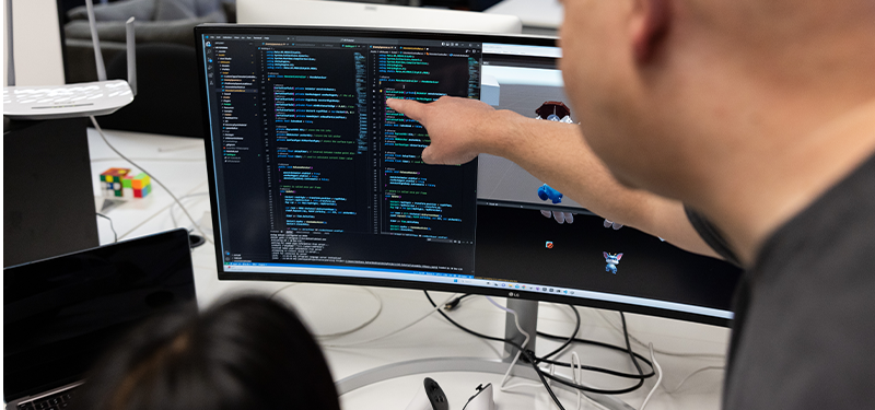 computer science student coding with professor
